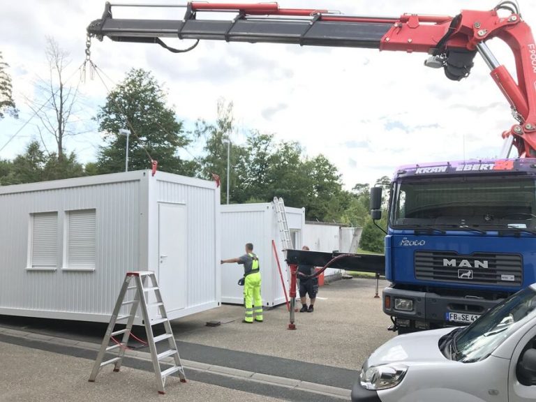 Aufstellung der Containeranlage per Ladekran auf dem gesicherten Gelände