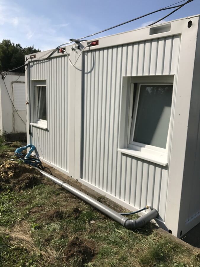 Containerwand mit Elektro-Anschlüssen und vorbereiteter Wasserleitung