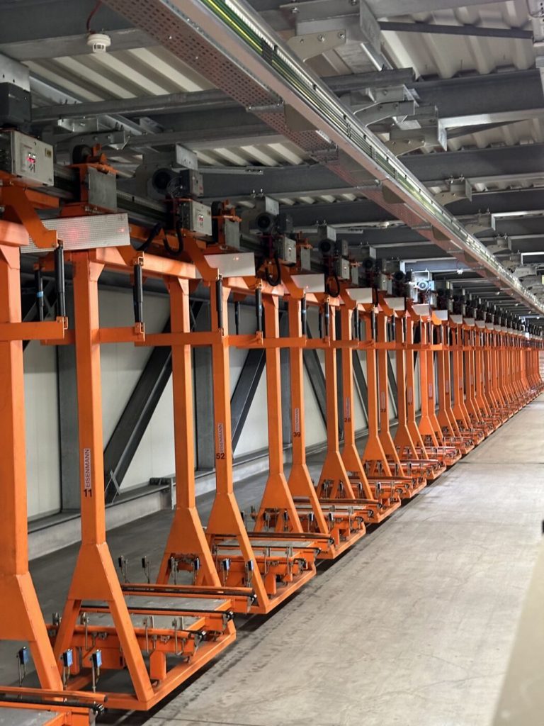 Reihe von Elektrohängebahn-Fahrzeugen in der Produktionshalle