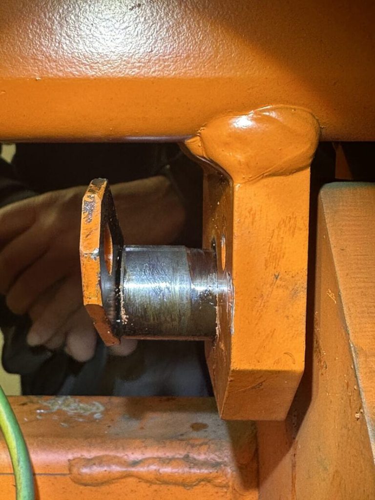 Bolzen im Gehänge eines Elektrohängebahn-Fahrzeugs vor dem Ausbau