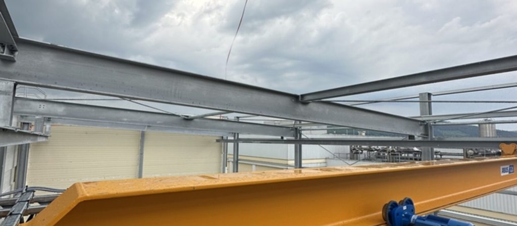 Blick über die Stahlkonstruktion – parallel schweben die ersten Dachpaneele ein