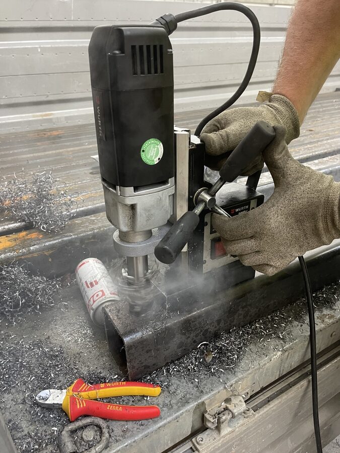 Kernbohrer der Magnetbohrmaschine arbeitet sich durch das 10-mm-Vierkantrohr