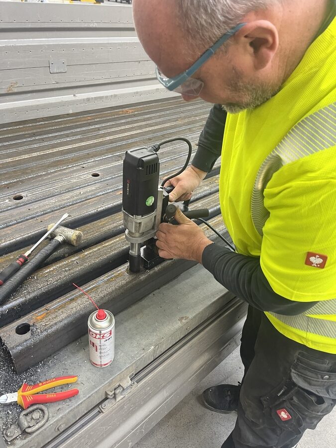 Schlosser bohrt das Loading Dock mit der Magnetbohrmaschine für den Rammschutz vor