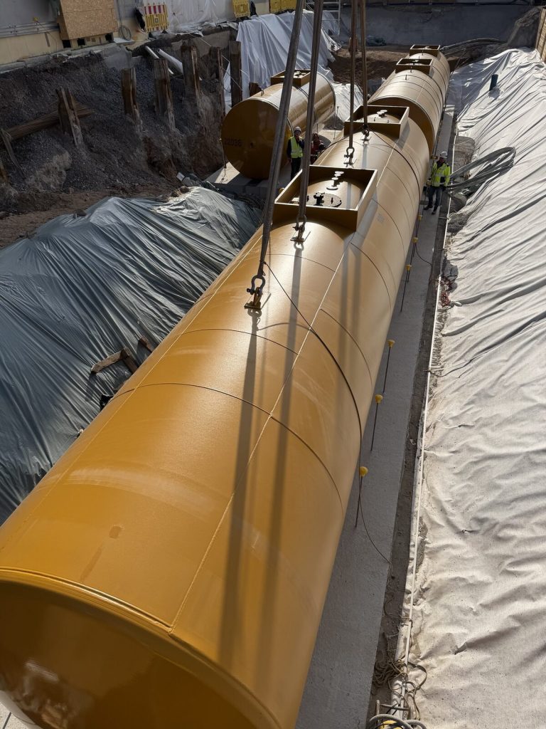 Dieseltank wird zwischen Verbauwand und Betonsohle in die vorbereitete Grube abgesenkt