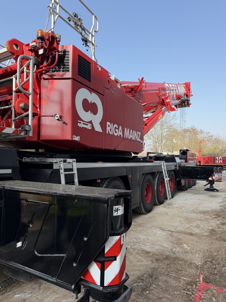 Gerüsteter Mobilkran mit ausgefahrenen Stützen auf der Baustelle des Rechenzentrums