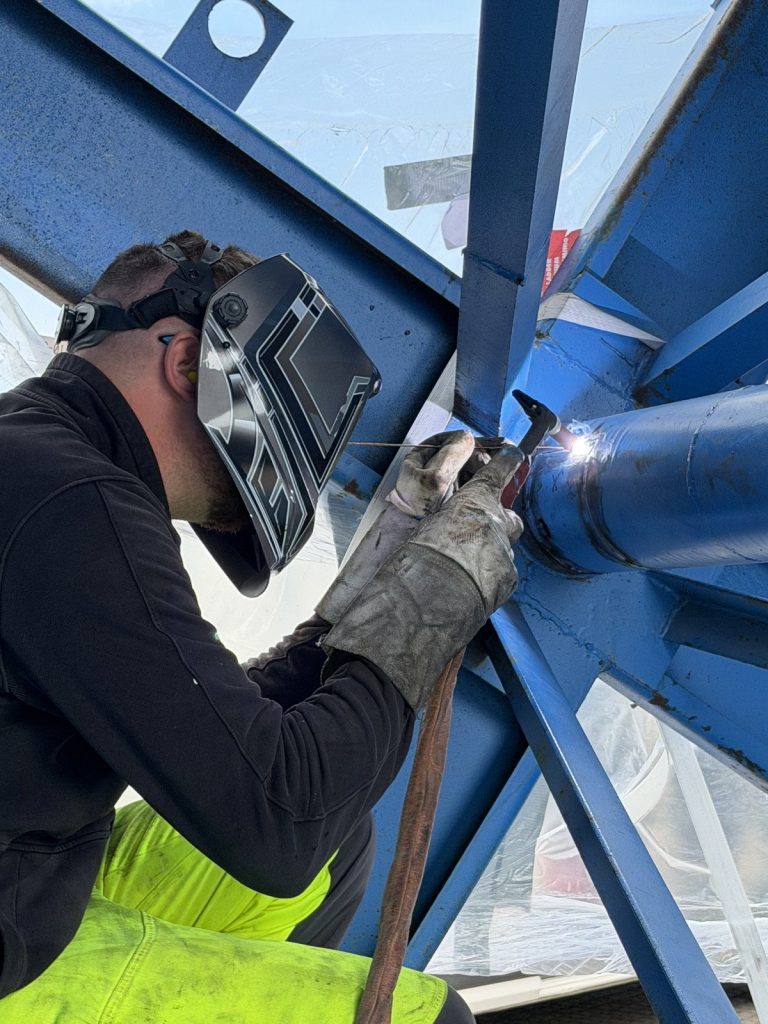 Schweißer arbeitet im beengten Inneren der Kabeltrommel