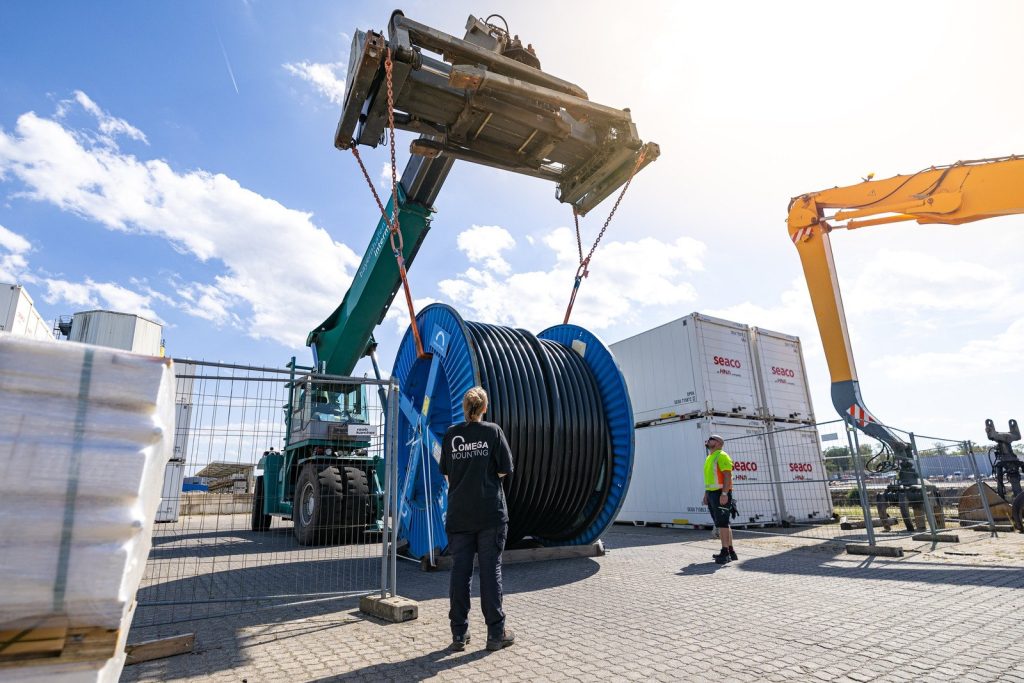 Monteurin der Omega Mounting Crew begleitet den Hub der Kabeltrommel im Hafen Aschaffenburg