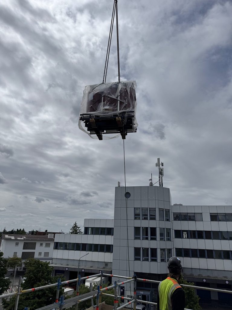 Gießharztransformator am Kranhaken über einem Rechenzentrum im Rhein-Main-Gebiet, eingehüllt für die Einbringung