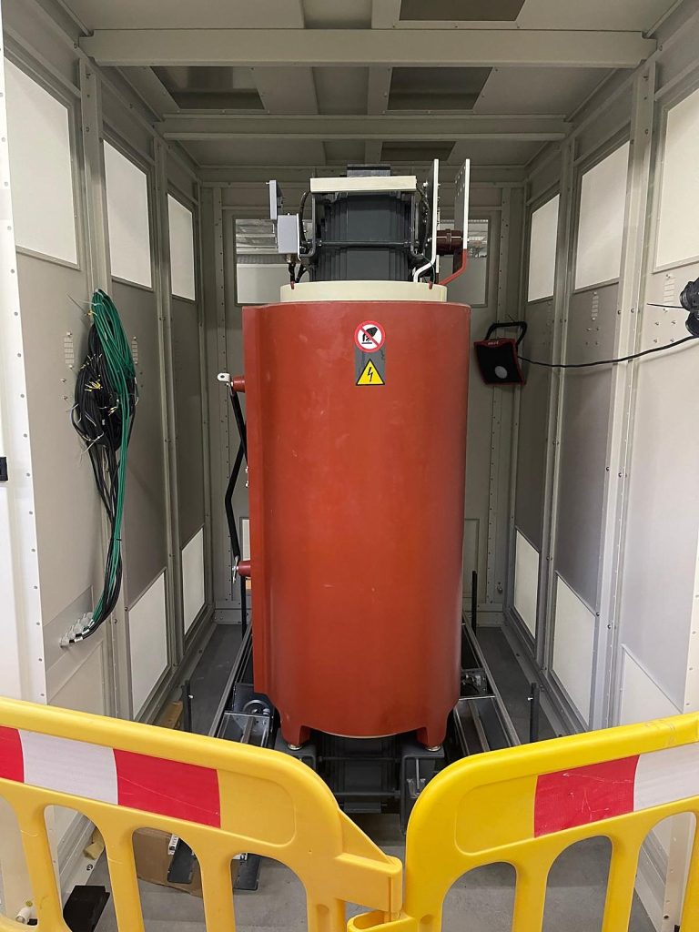 Transformator in der Trafozelle mit Absperrung, bereit für den Anschluss durch die Elektrofachkraft