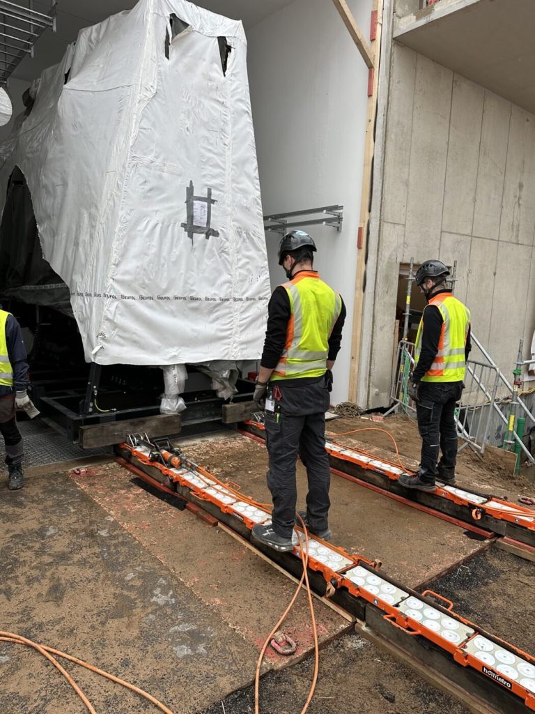 Monteure der Omega Mounting Crew begleiten den Verschub des Transformators