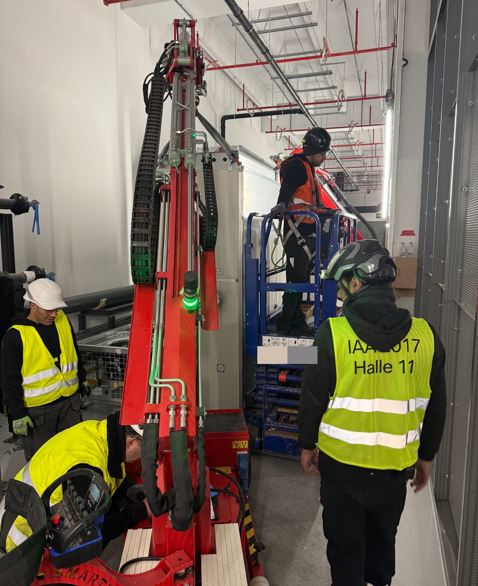 Electric mini crane moving a CRAH unit through a technical corridor in a data center