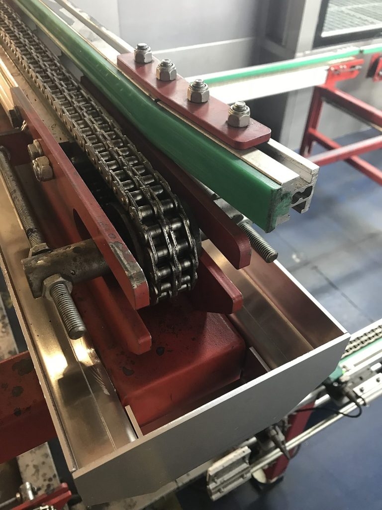 Spannstation eines Kettenförderers mit Gleitleiste in einer Lackieranlage