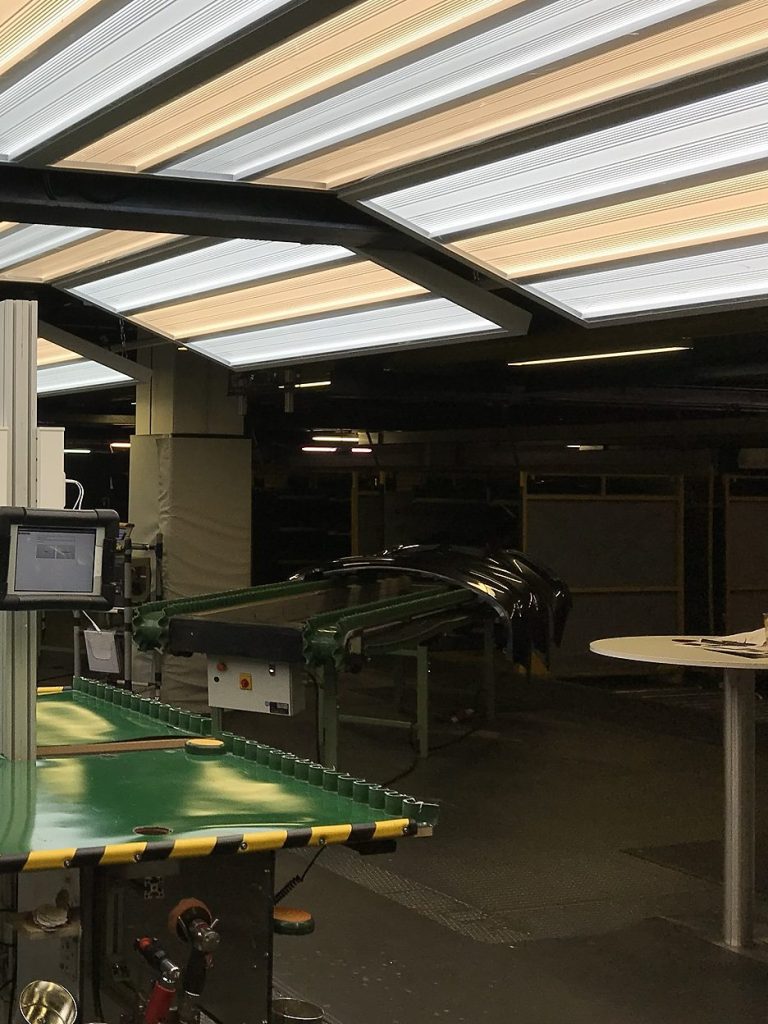 Kontrollzone mit Lichttunnel und Förderband für lackierte Stoßfänger bei einem Automobilzulieferer